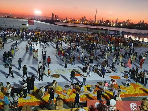 People of different nationalities create the largest natural flower carpet to showcase the UAE's tolerance and unity of its residents. PHOTO: Virendra Saklani