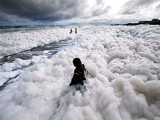 India: Children play on as polluted foam hits Chennai beach