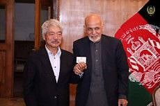Afghanistan's President Ashraf Ghani (R) and Japanese doctor Tetsu Nakamura pose for a photo, in this undated picture, in Kabul, Afghanistan.