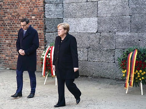 German Chancellor Angela Merkel and Polish Prime Minister Mateusz Morawiecki leave after laying wreathes at the Death Wall during their visit at the former German Nazi death camp Auschwitz-Birkenau in Oswiecim, Poland on December 6, 2019. 