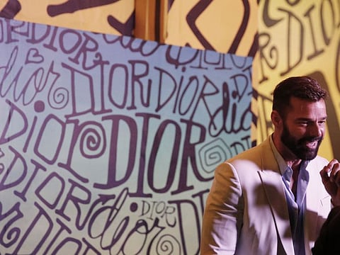 In this Tuesday, Dec. 3, 2019, photo, singer Ricky Martin gives an interview after the Christian Dior pre-fall 2020 men's fashion show during Miami Art week, in Miami. (AP Photo/Brynn Anderson)