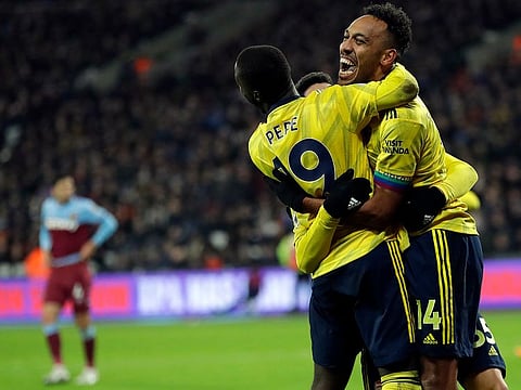 Arsenal's Pierre-Emerick Aubameyang, right, celebrates with teammates after scoring his side's third goal
