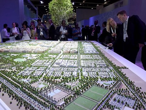 Visitors look at the model of Masdar City at the opening of Abu Dhabi Sustainability Week 