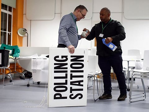 Workers prepare signs at their polling station on general election day in London, Britain, December 12, 2019. 