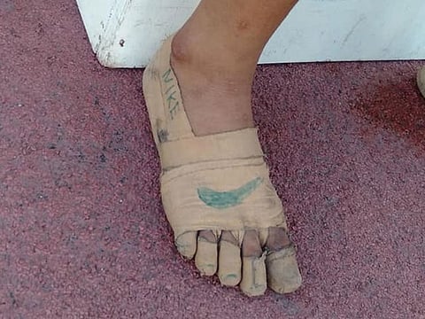 Rhea Bullos, 11, wears tape as makeshift running shoes during a 1500-meter run at the Iloilo Sports Complex, in Iloilo, Philippines.