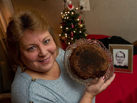 In this Dec. 9, 2019, photo Julie Ruttinger, of Tecumseh, Mich., holds a 141-year-old fruitcake, a family heirloom baked by her great-great-grandmother, Fidelia Ford, in 1878. 