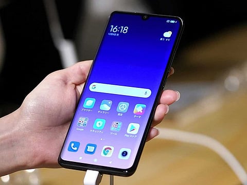 An attendee holds a Xiaomi Corp. Mi Note 10 smartphone during a news conference.