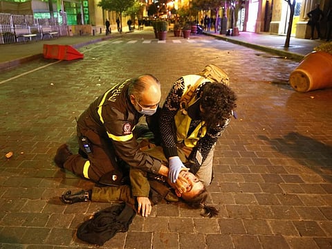 Civil defense workers treats an injured protesters who beaten heavily by riot Policemen , during a protest for the anti-government protesters who try to enter the parliament square, in downtown Beirut, Lebanon, Saturday, Dec. 14, 2019.