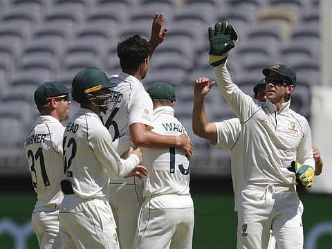 Australia's Mitchell Starc (third left) and skipper Tim Paine celebrate the dismissal of New Zealand's Jeet Raval on fourth day of their Test match in Perth on Sunday. 
