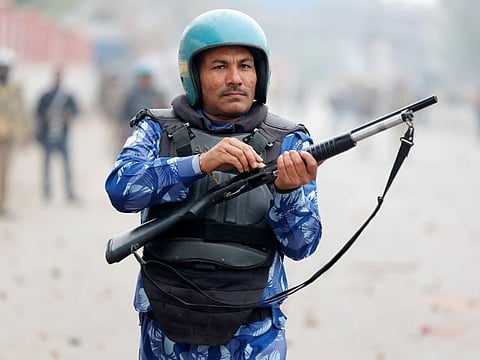 A riot police officer loads a rifle during a protest against a new citizenship law in Seelampur, area of Delhi, India  December 17, 2019. REUTERS/Adnan Abidi