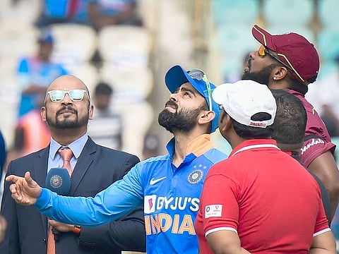 Virat Kohli flips the coin as West Indies Captain Kieron Pollard looks on during the toss before the start of 2nd One Day International match at ACA-VDCA Cricket Stadium in Visakhapatnam, Wednesday, December 18, 2019. 