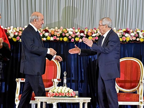 Algerian President-elect Abdelmadjid Tebboune (L) greets interim president Abdelkader Bensalah (R) during the formal swearing-in ceremony in the capital Algiers on December 19, 2019. The 74-year-old Tebboune, a former prime minister seen as close to the country's powerful military chief, reportedly garnered 58.13 percent of votes in the first ballot of a highly contested presidential election, according to the announced final results. 