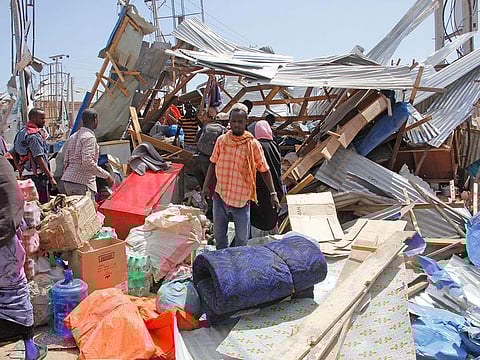 Somalis salvage goods after shops were destroyed in a car bomb in Mogadishu, Somalia, Saturday, Dec. 28, 2019. 
