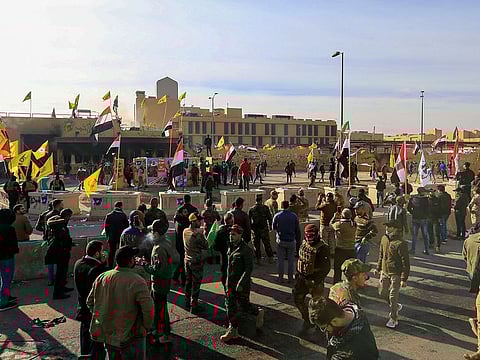 Protesters and militia fighters gather to condemn air strikes on bases belonging to Hashd al-Shaabi (paramilitary forces), outside the U.S. Embassy in Baghdad, Iraq January 1, 2020