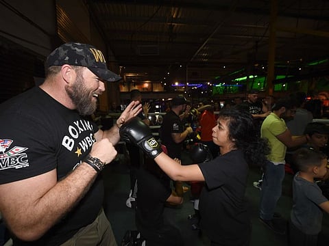 Former British heavyweight Scott Welch holds an impromptu sparring session with a children of determination on Friday