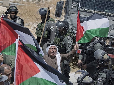 In this Aug. 16, 2019 file photo, Israeli border police block the road and disperse Palestinian, Israeli and foreign activists during a rally protesting a newly established settlement near the West Bank village of Kufr Malik, East of Ramallah.  