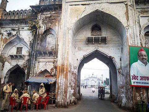 Police officers sit gather at a gate to the Hussainabad Imambara complex in Lucknow, Uttar Pradesh, India, on Monday, Dec. 30, 2019.