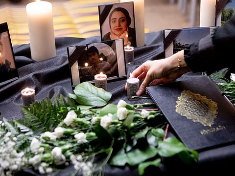A candle is placed on a table bearing photos of some of the victims of a Ukraine International Airlines passenger flight that crashed after takeoff near Tehran