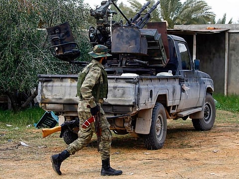 A fighter loyal to the Libyan Government of National Accord (GNA) walks past a vehicle in an area south of the Libyan capital Tripoli on January 12, 2020