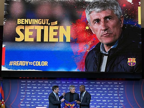 Barcelona's president Josep Maria Bartomeu (left) and football director Eric Abidal (right) flank Barcelona's new coach Quique Setien during his official presentation in Barcelona on Tuesday.
