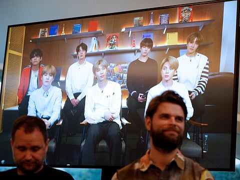 Danish artist Jakob Kudsk Steenson (R) sits in front of a monitor live-streaming South Korean boyband 'BTS' during the announcement of his new work 'Catharsis' at the launch of the global public art project "Connect, BTS", at Serpentine Gallery in London on January 14, 2020.  Steenson's work features a digital simulation of a re-imagined old-growth forest and is part of the contemporary art project, "Connect, BTS", which features 22 artists in five cities on four continents, - RESTRICTED TO EDITORIAL USE - MANDATORY MENTION OF THE ARTIST UPON PUBLICATION - TO ILLUSTRATE THE EVENT AS SPECIFIED IN THE CAPTION
 / AFP / ADRIAN DENNIS / RESTRICTED TO EDITORIAL USE - MANDATORY MENTION OF THE ARTIST UPON PUBLICATION - TO ILLUSTRATE THE EVENT AS SPECIFIED IN THE CAPTION