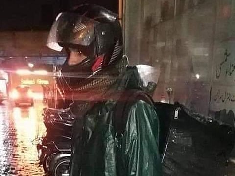 The delivery boy, taking refuge from the heavy rain.