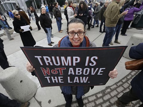 Marcie Hanks gathers with others outside the office of Sen. Mitt Romney to call on him to push for a full and fair impeachment trial in the Senate with pertinent testimony and evidence during a rally Thursday, Jan. 16, 2020, in Salt Lake City. 