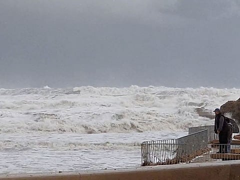 People watch as waves from Storm Gloria crash onto the shore in Javea, Spain January 20, 2020 in this still image taken from social media video. 