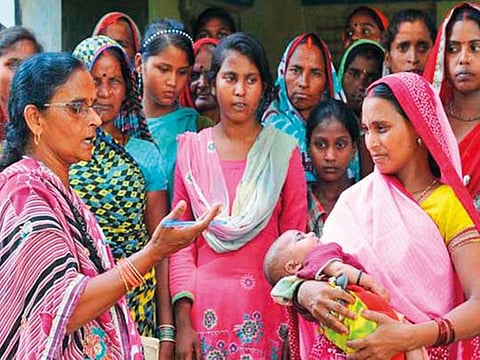 An Accredited Social Health Activist (ASHA) counselling a rural woman. ASHAs are credited with bringing down infant mortality rates in India