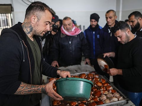 Gabriele Rubini (L), known as Chef Rubio, cooks with Palestinian prisoners at a Hamas-run civilian prison in Gaza City on January 21, 2020, where he is teaching the inmates how to cook Italian food and they teach him Palestinian recipes. 
