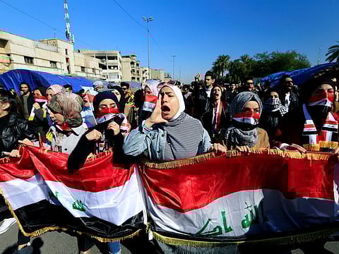 University students shout slogans, during ongoing anti-government protests in Baghdad on January 26.