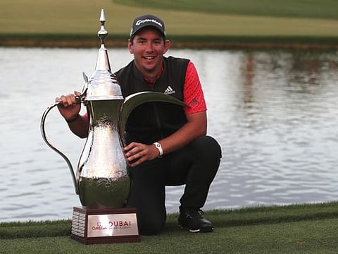 Australia's Lucas Herbert celebrates with his trophy after winning the Dubai Desert Classic golf tournament on Sunday.