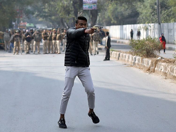 An unidentified man brandishes a gun