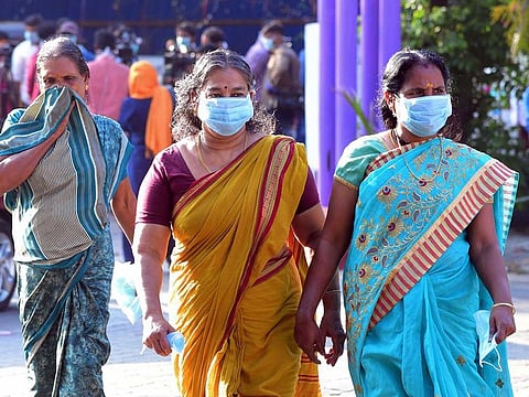 Residents and hospital visitors wearing facemaks walk outside the Government Medical College in Thrissur where the first confirmed case of the SARS-like virus in India is kept in isolation.