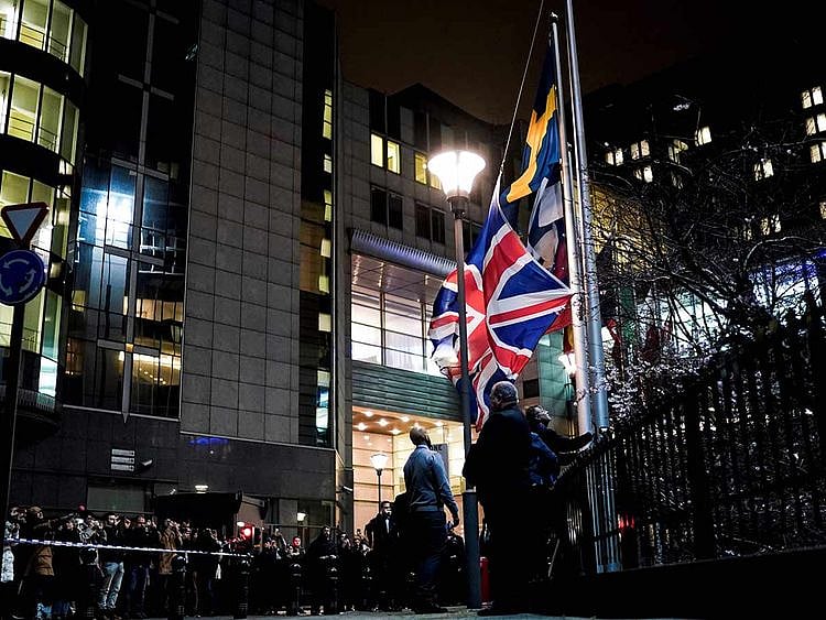 People take down the United Kingdom's flag from outside the European Union Parliament in Brussels,on Brexit Day, January 31, 2020