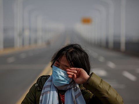 A mother reacts as she pleads with police to allow her daughter to pass a checkpoint for cancer treatment after she arrived from Hubei province at the Jiujiang Yangtze River Bridge in Jiujiang