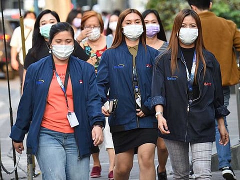 Office employees wearing facemasks walk along a street in Manila. Preventive measures implemented by countries to halt the COVID-19 outbreak in its tracks are forcing us to make fundamental changes to how we live - from work to play, business to education, policymaking to legislation.