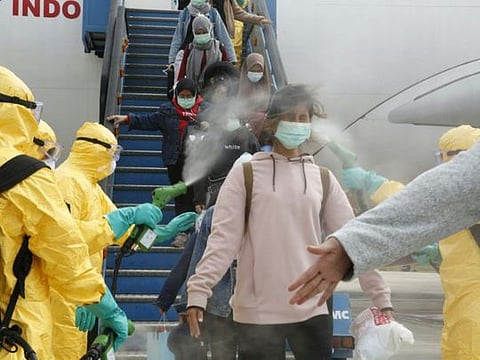 Indonesian students are disinfected as they disembark at the Hang Nadim international airport in Batam, following their evacuation from the Chinese city of Wuhan due to the coronavirus outbreak.