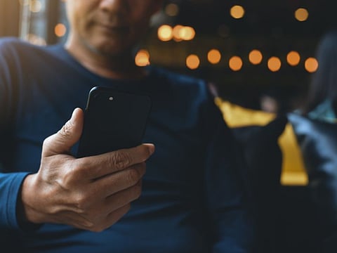 For illustrative purposes only, man holding phone. A Dubai telecoms staffer used top up card cash to buy a Bentley     