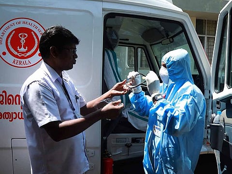An ambulance driver (R) of Ernakulam medical college puts on gears up with protective apparel to help stop the spread of a deadly SARS-like virus, as he prepares before going to pick a suspected virus patient, in Kochi on February 4, 2020. 