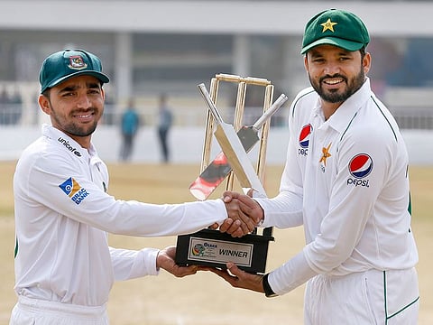 Pakistan skipper Azhar Ali, right, and his Bangladesh counterpart Mominul Haque shakes hand while they pose for a photograph with the test series trophy at the Pindi Cricket Stadium, in Rawalpindi, on Thursday. 
