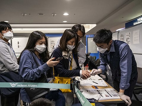 Travel documents are inspected at a quarantine checkpoint at Incheon International Airport in Incheon, South Korea on Friday, Feb. 14, 2020. China on Friday reported 5,090 new coronavirus cases and 121 new deaths in the previous 24 hours. (Lam Yik Fei/The New York Times)