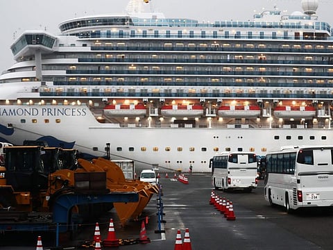 Two buses arrive next to the Diamond Princess cruise ship, with people quarantined onboard due to fears of the new coronavirus, at the Daikaku Pier Cruise Terminal in Yokohama port on February 16, 2020. The number of people who have tested positive for the new coronavirus on a quarantined ship off Japan's coast has risen to 355, the country's health minister said. / AFP / Behrouz MEHRI