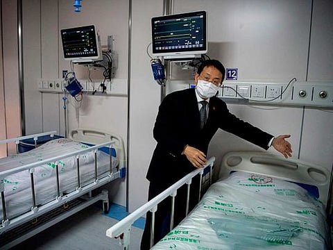Lu Hongzhou, co-director of the Shanghai Public Health Clinical Center, gestures as he shows the quarantine room for COVID-19 coronavirus patients at the hospital building A2, in Shanghai 