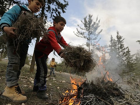 Internally displaced children start a fire at a makeshift camp in Qatmah village, West of Azaz, Syria.