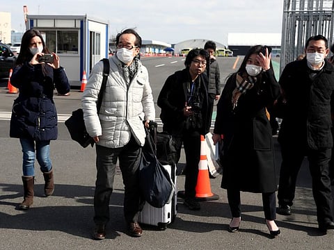 Passengers wearing face masks walk out from the cruise ship Diamond Princess at Daikoku Pier Cruise Terminal in Yokohama, south of Tokyo, Japan February 19, 2020. REUTERS/Athit Perawongmetha