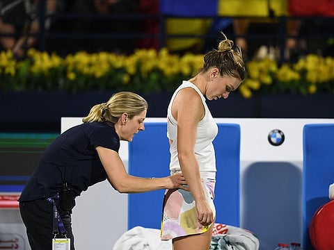 Romania's Simona Halep receives medical attention as she faces with Ons Jabeur of Tunisia.