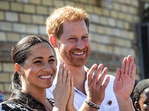 In this file photo taken on September 23, 2019 Prince Harry, Duke of Sussex and Meghan, Duchess of Sussex arrive to visit the "Justice desk", an NGO in the township of Nyanga in Cape Town, as they begin their tour of the region. 