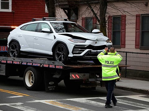 A police officer photographs one of two stolen Lamborghinis that were recovered following crash in Malden, Massachusetts.