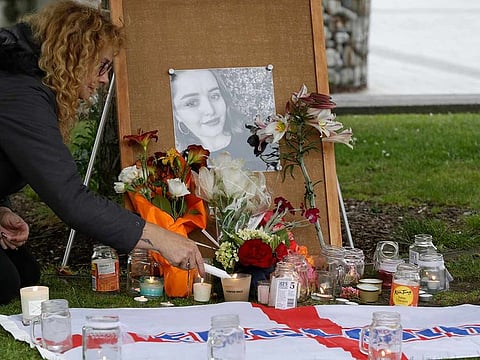In this Dec. 12, 2018, file photo, a woman lights candles during a candlelight vigil for murdered British tourist Grace Millane at Cathedral Square in Christchurch, New Zealand.